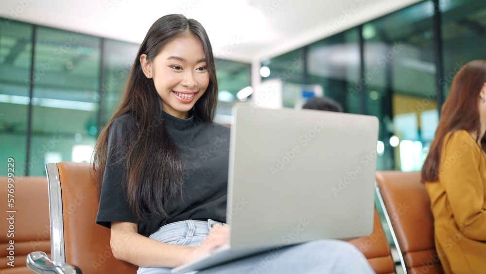 Passenger traveler Asian woman in airport gate working laptop while waiting boarding air before vacation travel Passenger traveler Asian woman in airport gate working laptop while waiting boarding air before vacation travel