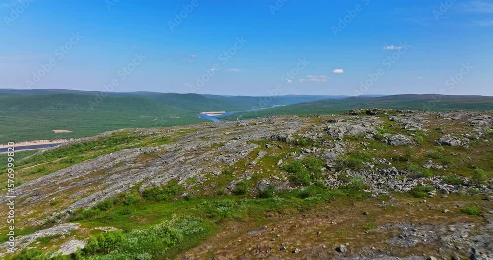 Aerial view low over a rocky mountain, revealing the Teno river, sunny summer day in Utsjoki, Finland Aerial view low over a rocky mountain, revealing the Teno river, sunny summer day in Utsjoki, Finland
