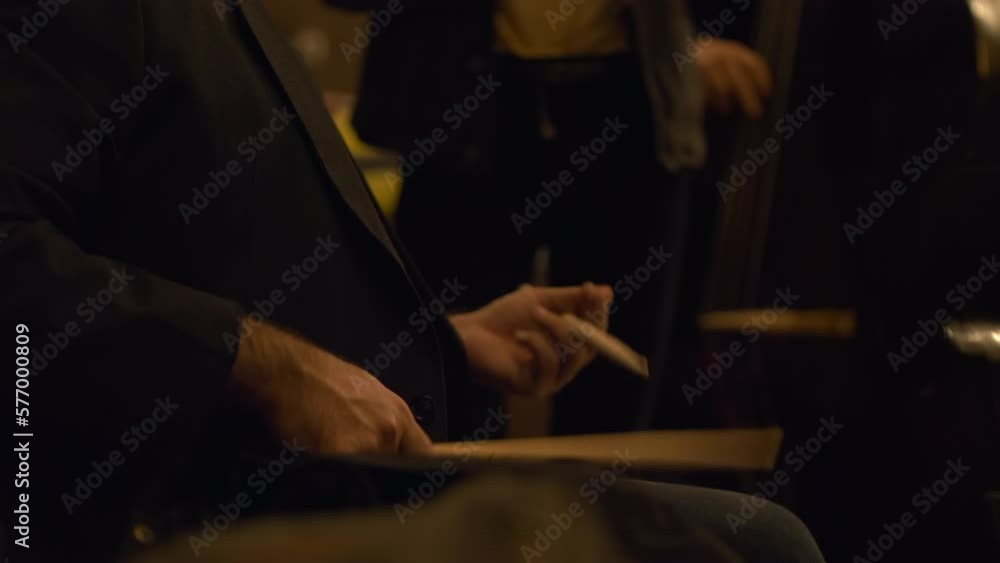 Drummer practice with drumsticks on his legs before concert, close up view Drummer practice with drumsticks on his legs before concert, close up view