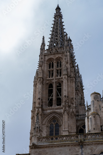 El campanario de la Catedral de Burgos bajo el cielo soleado vista desde abajo viendo los detalles de las vidrieras.