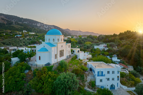 Aerial view of the Lagoudi Zia Church on Greek island of Kos. Typical blue roofs monastery near Zia town against Sunset. Vibrant colors, no people, calm atmosphere.