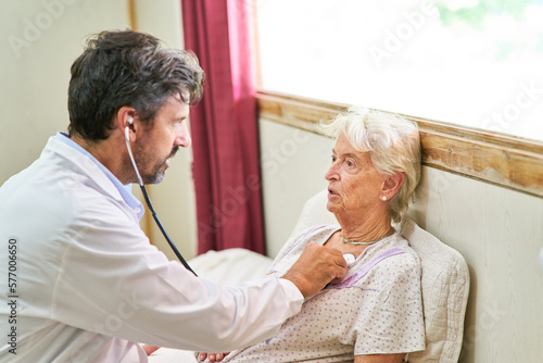 Doctor with a stethoscope auscultating an elderly woman