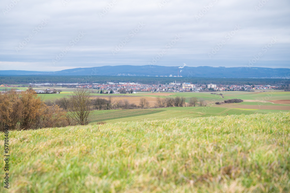 Cityscape of Schaafheim, with agricultural fields in the front and Mountain range in the background during cloudy day, Germany