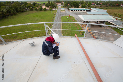 Female worker inspection roof storage tank
