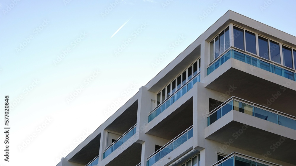 white facade with balconies against sky white facade with balconies against sky