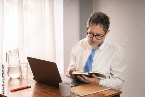 Businessman reading planner in office - Mature businessman with glasses reading agenda