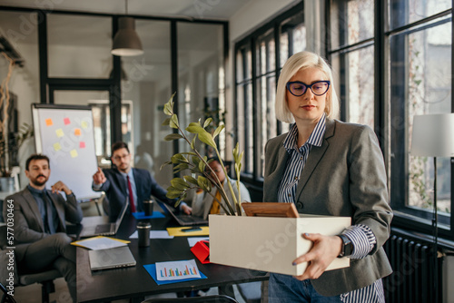 Foto Mid adult Caucasian woman getting fired from work
