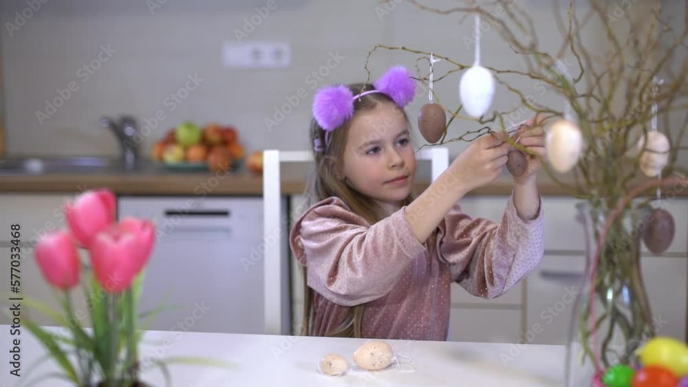 Easter scene. The girl plays with colorful eggs. Decorative eggs for Easter in a basket and on branches. Easter scene. The girl plays with colorful eggs. Decorative eggs for Easter in a basket and on branches.