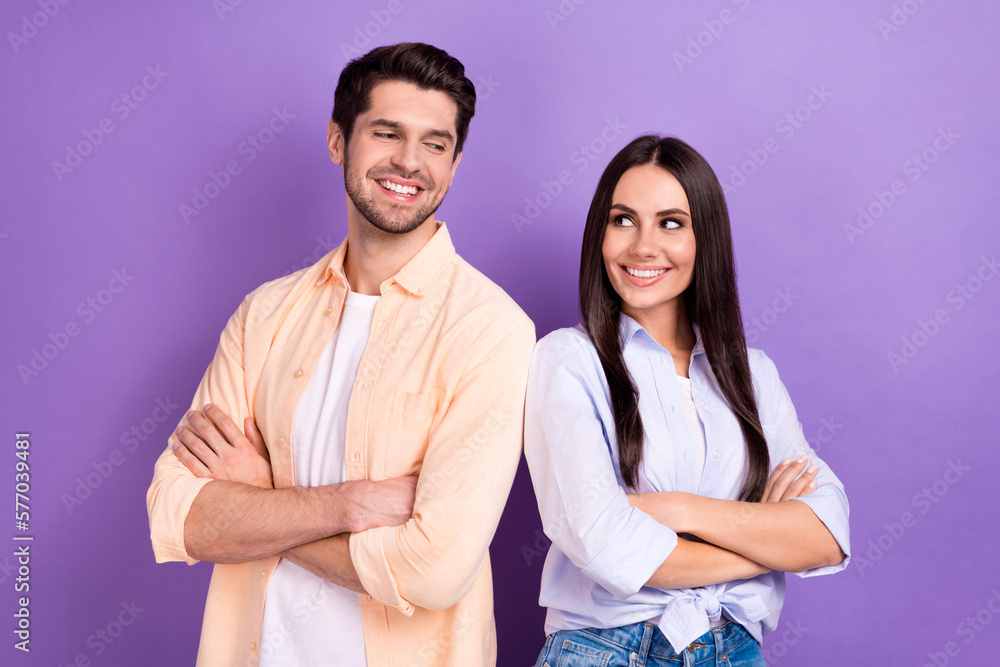 Photo of charming funny husband wife dressed shirts arms folded looking each other isolated purple color background Photo of charming funny husband wife dressed shirts arms folded looking each other isolated purple color background