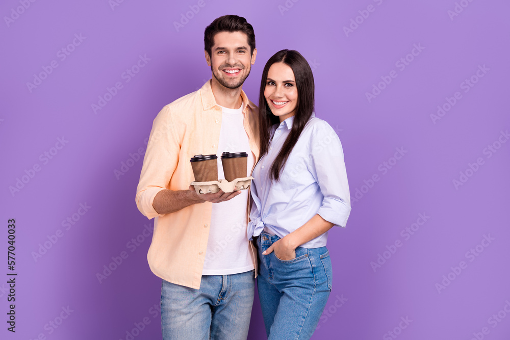 Naklejka premium Photo of young positive students together hold paper cups coffee enjoy drinking fresh latte morning macchiato isolated on violet color background