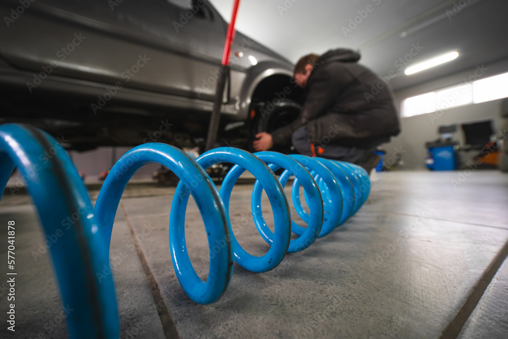 Man car servise changing wheels. A spring hose to a pneumatic tool