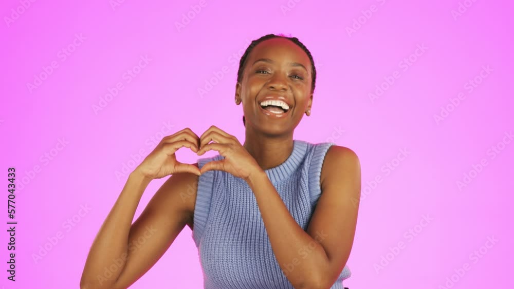 Face, hand gesture and heart with a black woman laughing in studio on a pink background for love or health. Portrait, emoji and romance with an attractive young female laughing on a color wall Face, hand gesture and heart with a black woman laughing in studio on a pink background for love or health. Portrait, emoji and romance with an attractive young female laughing on a color wall