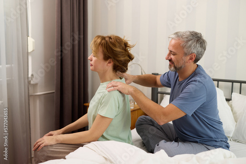 Mature man giving a neck massage to his wife at home