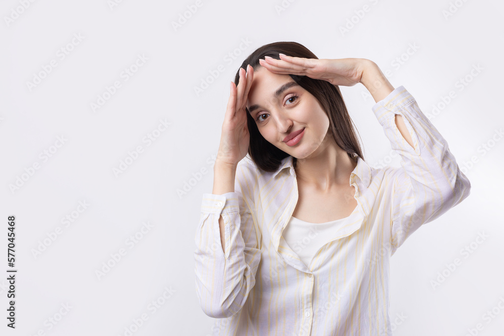 Portrait of a serious young woman showing stop gesture with her palm over white background Portrait of a serious young woman showing stop gesture with her palm over white background