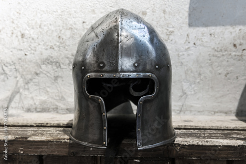 Obraz na plátně Steel helmet of medieval knight lays on a rough wooden shelf