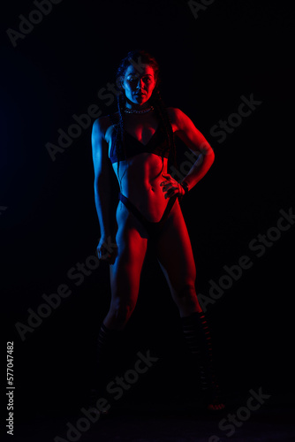 Beautiful female body on dark background in red blue neon light. Fit and sportive, sensual. © Ivan Zelenin