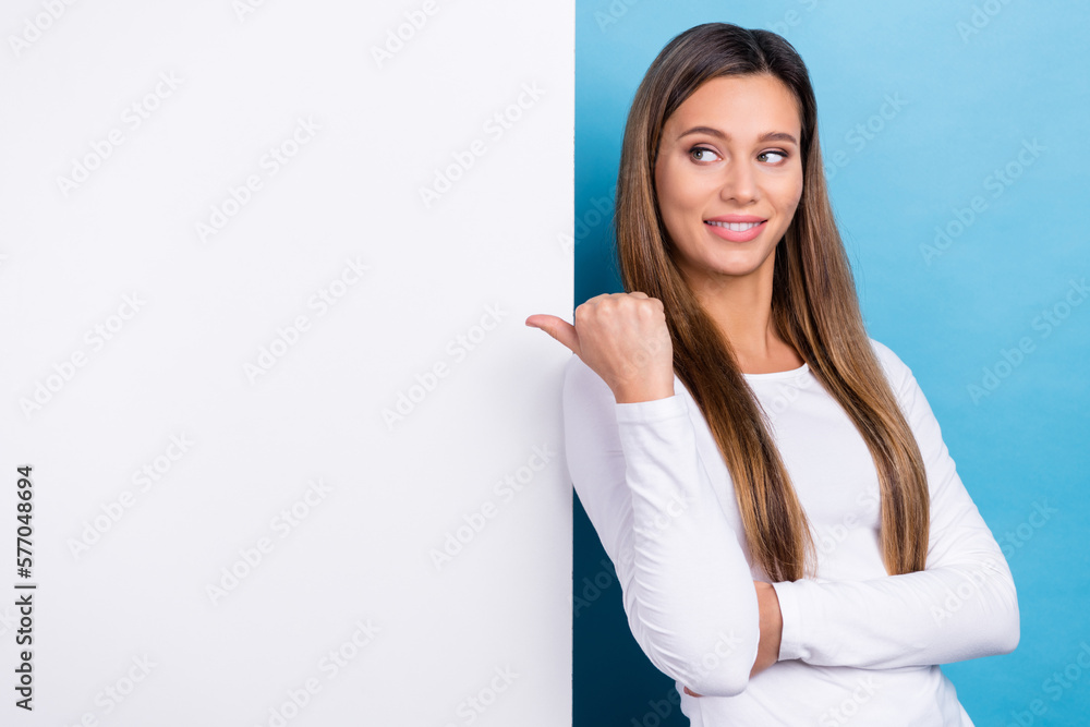 Photo of shiny cheerful lady dressed white shirt looking thumb back poster empty space isolated blue color background Photo of shiny cheerful lady dressed white shirt looking thumb back poster empty space isolated blue color background