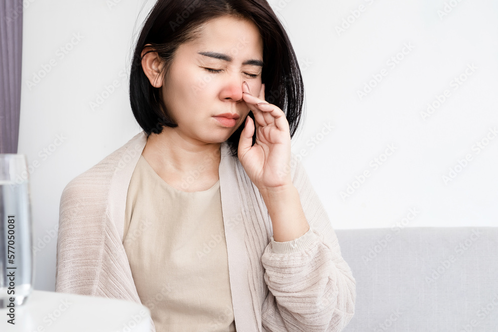 Asian woman suffering from stuffy nose having runny nose and bad breath caused by sinus infection Asian woman suffering from stuffy nose having runny nose and bad breath caused by sinus infection