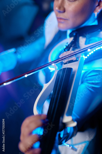 Portrait of young fashion violinist playing electronic music on violin