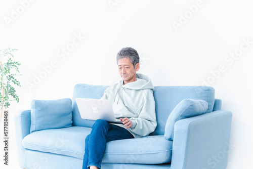 自宅でパソコンを使う高齢の男性 © maroke