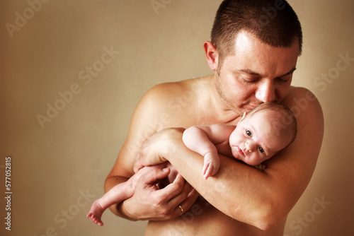 Closeup portrait of young father holding his newborn baby. Fathers day holiday, love, care concept.