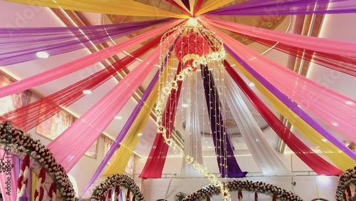 A low-angle, beautiful view of decoration with sarees and lighting at an event photo