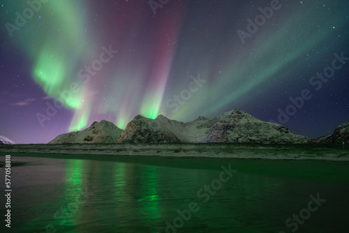 Rote und grüne Polarlichter über einem Berg in Norwegen