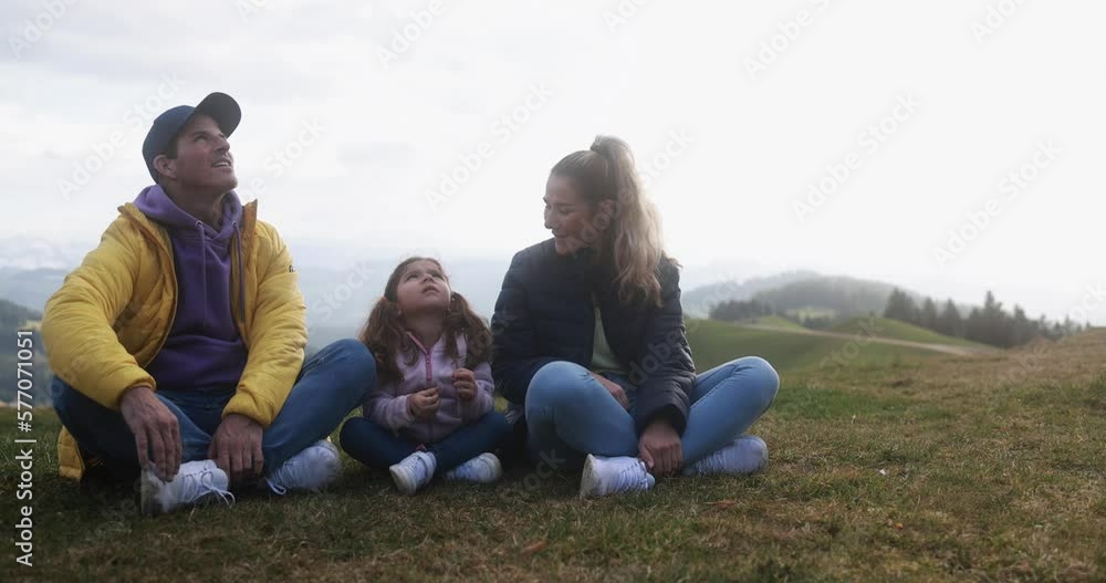Happy young family having fun taking a break during hiking day in swiss mountains Happy young family having fun taking a break during hiking day in swiss mountains