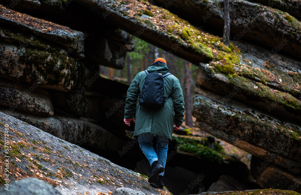 A tourist enjoys the beautiful scenery in northern Finland. Panorama of the autumn pine forest with formation rocks and faults. Northern nature. Nature of Finland autumn. Tourism northern landscape. A tourist enjoys the beautiful scenery in northern Finland. Panorama of the autumn pine forest with formation rocks and faults. Northern nature. Nature of Finland autumn. Tourism northern landscape.