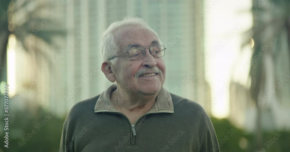 Close-up of senior man looking around a park and smiling Close-up of senior man looking around a park and smiling
