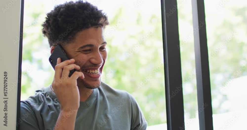 Happy biracial man talking on smartphone and smiling Happy biracial man talking on smartphone and smiling