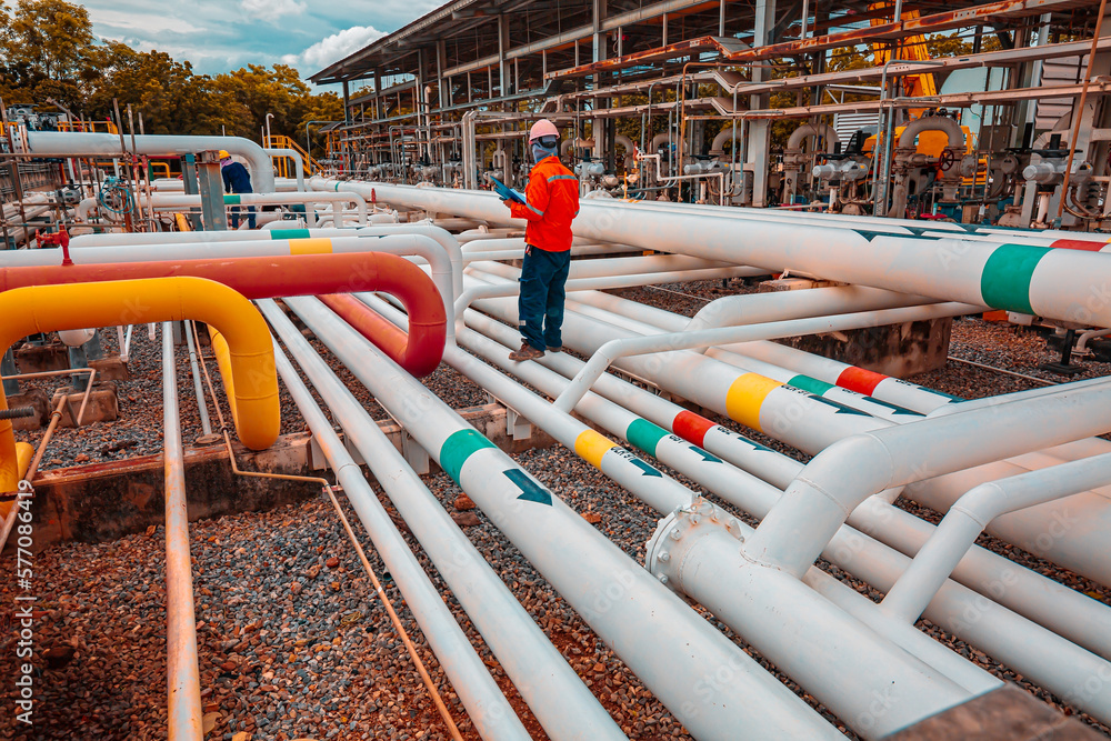 Male worker inspection at steel long pipes and pipe elbow in station oil factory during refinery valve of visual check record pipeline tank oil and gas Male worker inspection at steel long pipes and pipe elbow in station oil factory during refinery valve of visual check record pipeline tank oil and gas