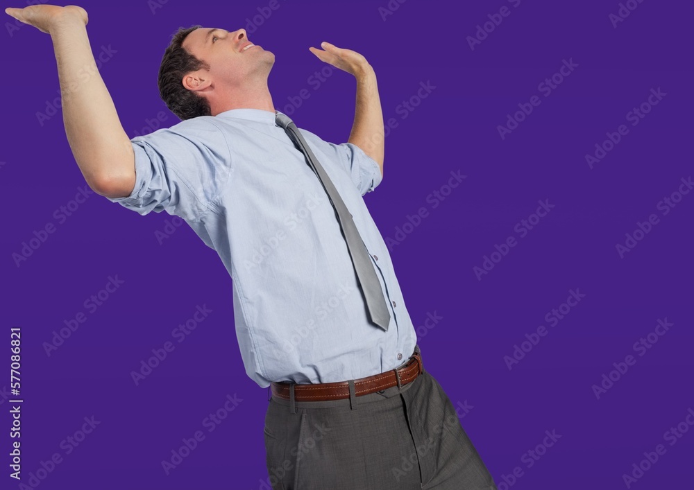 Caucasian businessman with his arms raised against copy space on blue background Caucasian businessman with his arms raised against copy space on blue background