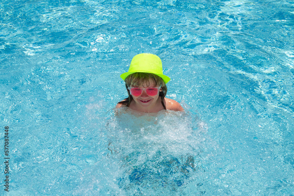 Child in swimming pool, healthy outdoor sport activity for children. Kids beach fun. Fashion summer kids in hat and pink sunglasses.