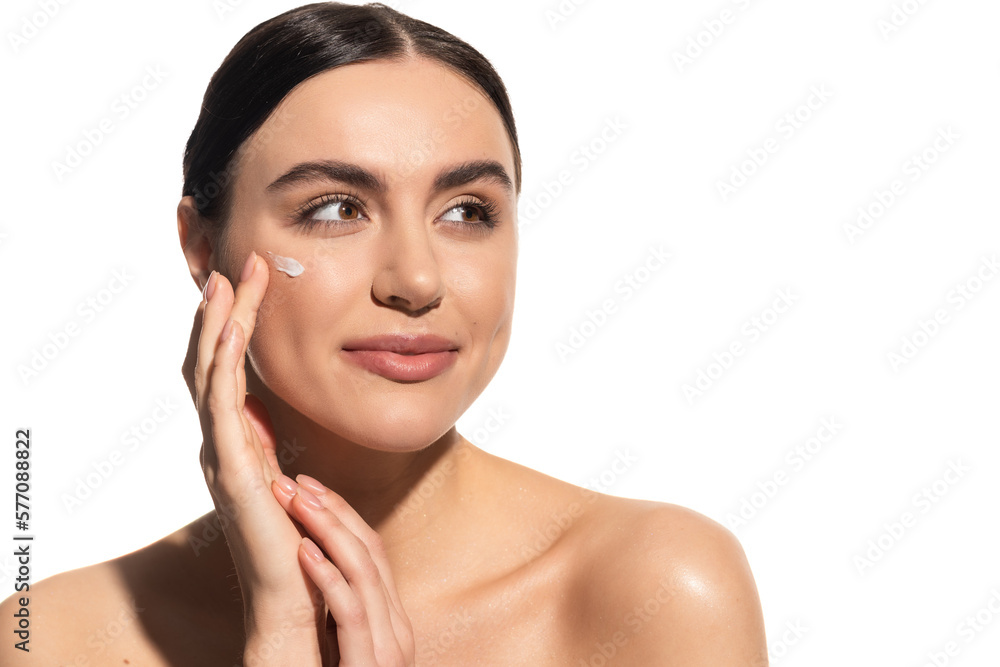 brunette young woman applying moisturizing face cream on cheek isolated on white. brunette young woman applying moisturizing face cream on cheek isolated on white.