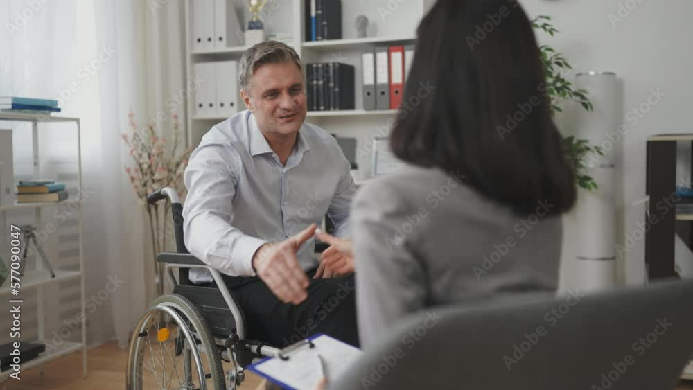Smiling man with disability shaking hands with psychologist, grateful for help Smiling man with disability shaking hands with psychologist, grateful for help