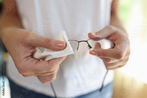 Woman wiping glasses with white cleaning napkin