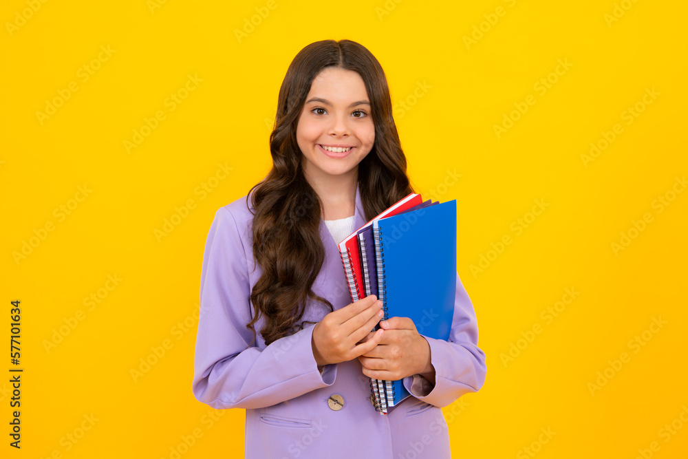 Teen girl pupil hold books, notebooks, isolated on yellow background, copy space. Back to school, teenage lifestyle, education and knowledge. Teen girl pupil hold books, notebooks, isolated on yellow background, copy space. Back to school, teenage lifestyle, education and knowledge.