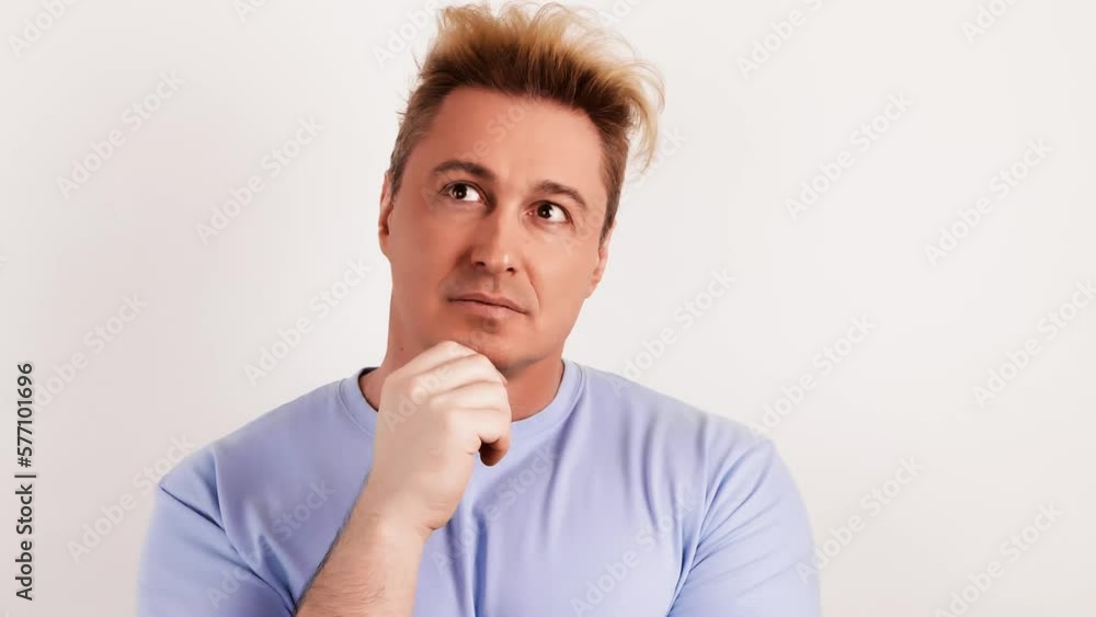 Pensive confused man thinking over choice, imagining plan in mind. Puzzled guy leaning hand having doubts, pondering idea. Indoor studio shot isolated on white background. Pensive confused man thinking over choice, imagining plan in mind. Puzzled guy leaning hand having doubts, pondering idea. Indoor studio shot isolated on white background.