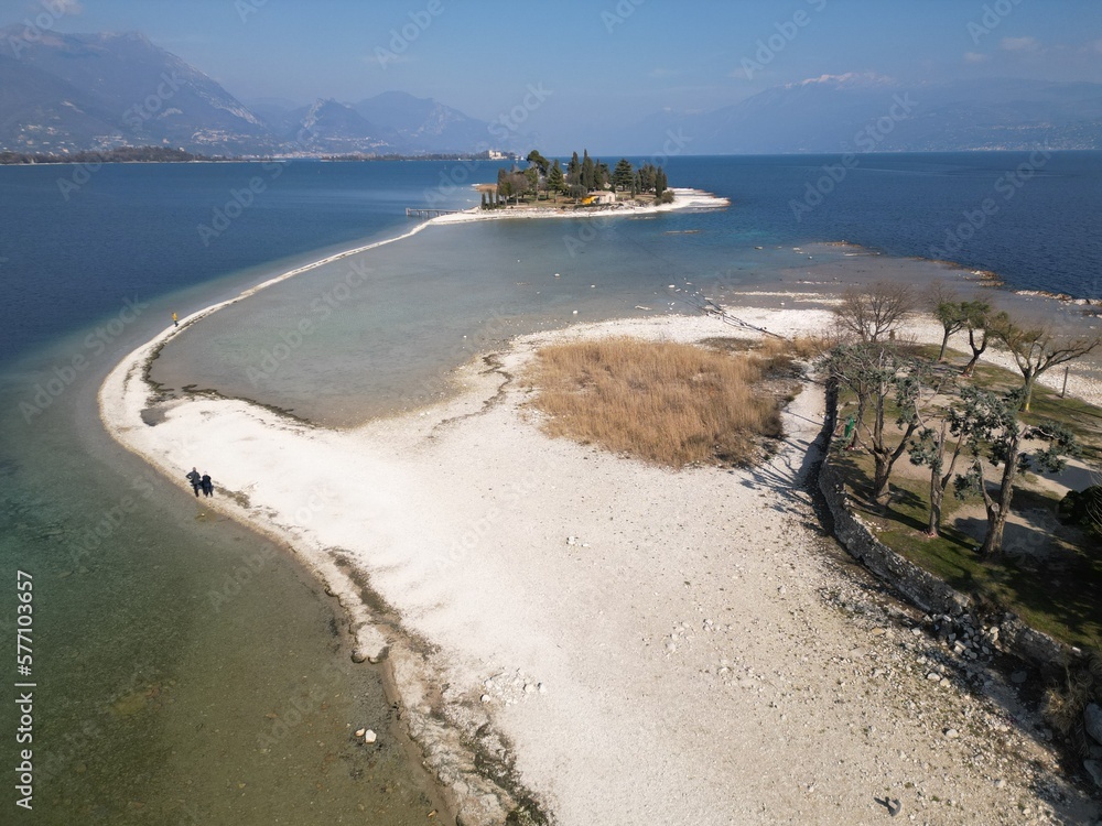 Italy, Lake Garda ,San Biagio Island , Rabbit Island - the shallow waters of the lake allow you to walk and reach the island on foot - water emergency in Lombardy , drought lowering of the water level