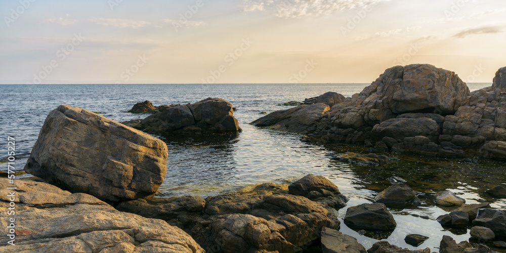 sea coast with stones and boulders in the morning. summer vacation background