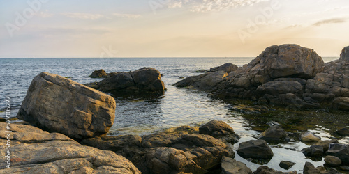 sea coast with stones and boulders in the morning. summer vacation background