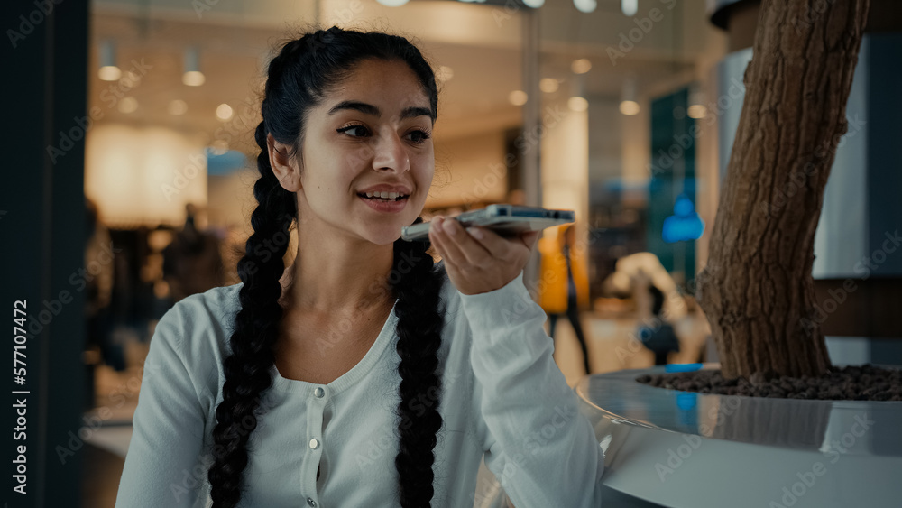 Young arabian woman girl shopper send voice message record audio speech talk on speakerphone activate sound app use ai assistance female businesswoman speak phone cell connection communicating online Young arabian woman girl shopper send voice message record audio speech talk on speakerphone activate sound app use ai assistance female businesswoman speak phone cell connection communicating online