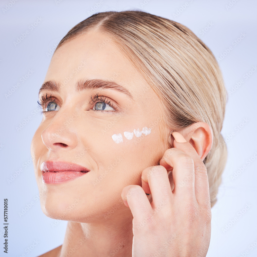 Beauty, face skincare and woman with cream in studio isolated on a blue background. Dermatology cosmetics, thinking and happy female model apply lotion, creme or moisturizer product for healthy skin. Beauty, face skincare and woman with cream in studio isolated on a blue background. Dermatology cosmetics, thinking and happy female model apply lotion, creme or moisturizer product for healthy skin.