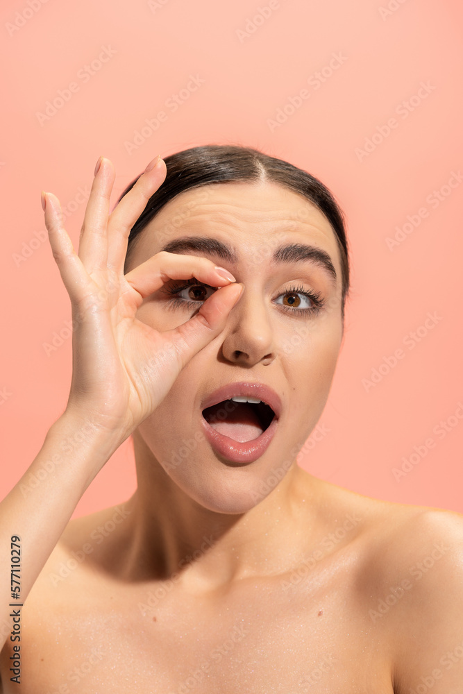 amazed woman with opened mouth showing ok sign isolated on pink. amazed woman with opened mouth showing ok sign isolated on pink.