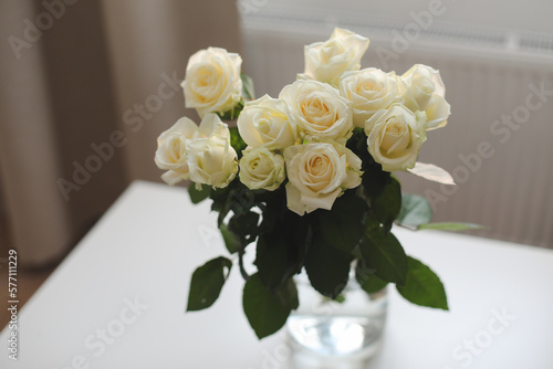 White rose bouquet in a cozy home interior. Floral spring romantic background, birthday, dating and love concept.