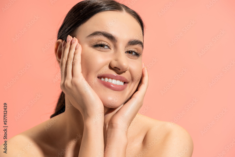 charming young woman with bare shoulders looking at camera while smiling isolated on pink. charming young woman with bare shoulders looking at camera while smiling isolated on pink.