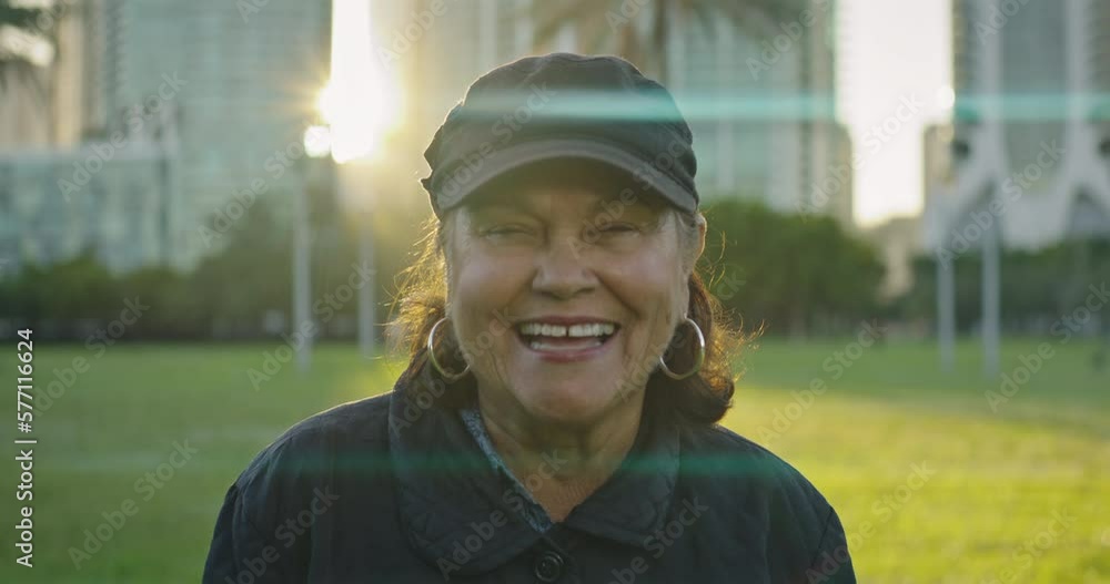 Woman in her 70s at park looking at camera with a big smile Woman in her 70s at park looking at camera with a big smile