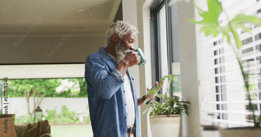 Video of african american senior man drinking coffee and using tablet Video of african american senior man drinking coffee and using tablet