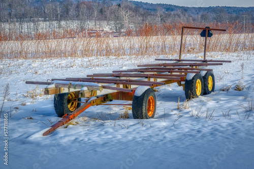 Old and well-used farm equipment sits along the field waiting for warming weather so they can be put to use again.  The farmer leaves equipment out in the elements here in Windsor in Upstate NY.       photo